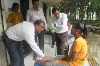 Dr VV Pai examines young patient with government officials.  Image: St Francis Leprosy Guild