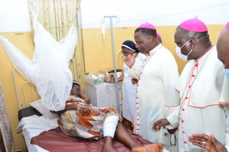 Bishop Arogundade visiting injured survivor of attack on St Francis Xavier's Church ©ACN