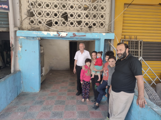 Tyre residents Salim Assaf and family outside their one-bedroom home Image: © ACN
