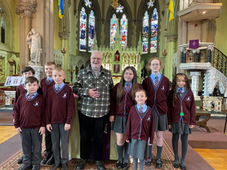 Faith Primary Academy pupils with Fr Denis