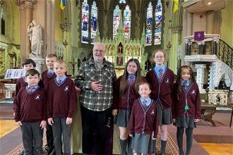 Faith Primary Academy pupils with Fr Denis