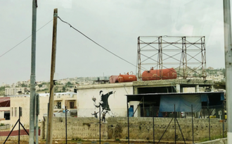 Flower Thrower (Love is in the Air),by Banksy,2005,  Spray paint on wall, Bethlehem  © Christian Art