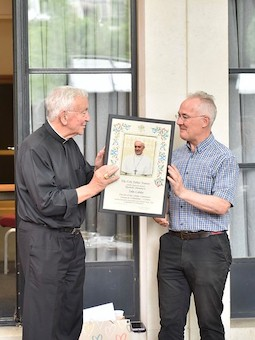 Cardinal presents John with Apostolic Blessing. Image Simeon Elderfield, Diocese of Westminster.