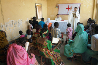 Comboni Father Jorge Naranjo seen here with his community in Sudan © ACN