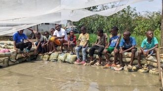 Fr Innocent and children at fishery