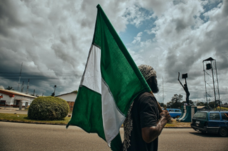 Man with Nigerian flag in Port Harcourt, Nigeria © Emmanuel Ikwuegbu