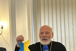 Bishop Nowakowski shows one of the 528 paper angels  that will be hanging in the Cathedral at tomorrow's service - one for each child killed.