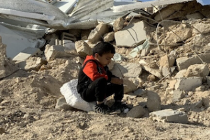 Child sits on rubble of family's demolished house, Jabal Al Mukkabir, East Jerusalem. Photo: OCHA