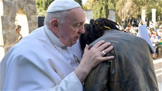 Pope with young migrant. Image: Vatican Media