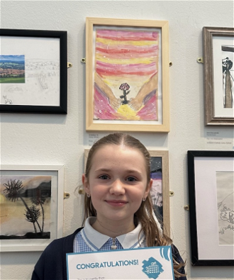 Daisy with her picture and award certificate