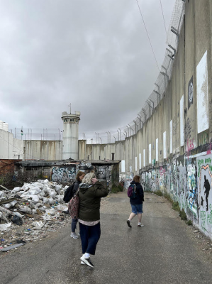 Pilgrims walk by Separation Wall, Bethlehem. ICN/JS