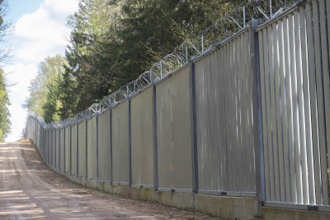 A five-metre-high wall of steel spans topped with razor wire was constructed by Polish authorities in 2022 along a 186-kilometre section of the border with Belarus. Image by Ingrid Prestetun/NRC
