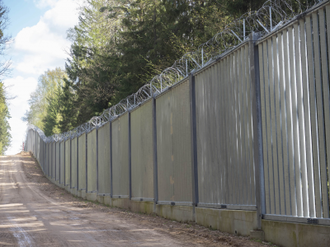 A five-metre-high wall of steel spans topped with razor wire was constructed by Polish authorities in 2022 along a 186-kilometre section of the border with Belarus. Image by Ingrid Prestetun/NRC