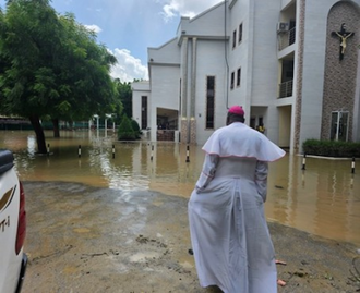 Bishop John Bakeni in front of  water-logged cathedral © ACN