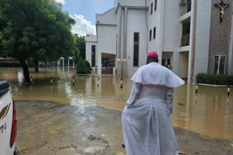 Bishop John Bakeni in front of water-logged cathedral, Maiduguri,  Nigeria  © ACN