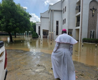 Bishop John Bakeni in front of water-logged cathedral, Maiduguri,  Nigeria  © ACN