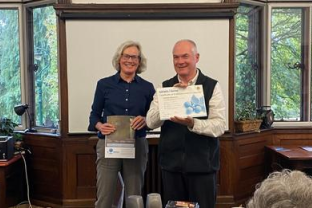 Felicite Dodd and Fr John Boles with the plaque