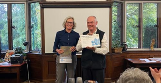 Felicite Dodd and Fr John Boles with the plaque