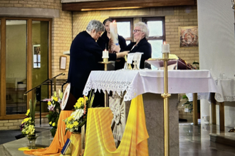 Sr Ellen passes the Province Candle to Sr Theresa