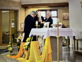 Sr Ellen passes the Province Candle to Sr Theresa