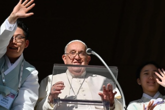 Pope Francis during the Angelus accompanied by two Korean young people