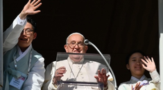 Pope Francis during the Angelus accompanied by two Korean young people