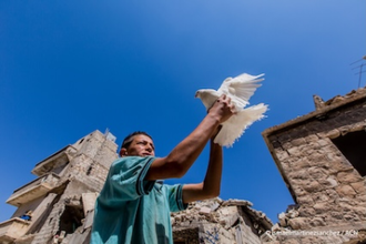 Refugee with dove in Aleppo -  Image: © Ismael Martínez Sánchez / ACN