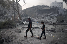 Father and child pass through rubble of buildings in Gaza. Image: UNICEF/UNI448939/Eyad El Baba