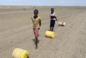 Children with water barrels