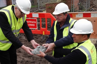 Bishop Peter Collins, John Latham Jr and Fr Philip John holding the blessed foundation stone.