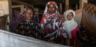 Families shelter in former bus station turned displacement site for nearly 6,000 people in Gedaref, Sudan. Photo: OCHA/Giles Clarke