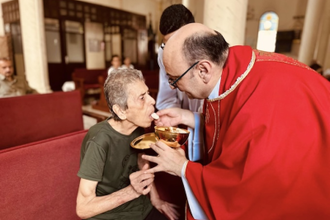 Fr Gabriel gives Communion to parishioner