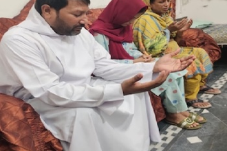 Fr Aslam prays with Asma and her mother © ACN