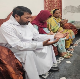 Fr Aslam prays with Asma and her mother © ACN