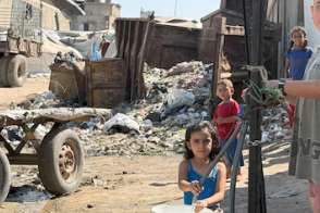 Children fill buckets with water in Gaza city. Photo by OCHA/Olga Cherevko