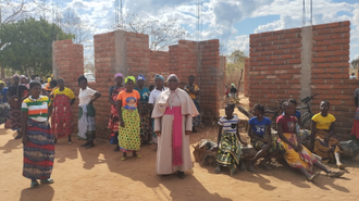 Bishop Canira with parishioners repairing church in rural community (Image: ACN)
