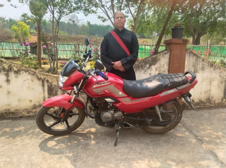Father Arvind Tigga with one of the new bikes. Image: ACN