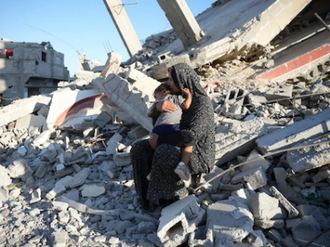 Mother and child on ruin of their home