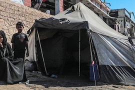 © UNICEF/Mohammed Nateel  Displaced family sit outside their tent in Gaza.