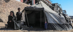 © UNICEF/Mohammed Nateel  Displaced family sit outside their tent in Gaza.