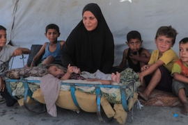 Displaced family in front of their tent in Gaza. © UNICEF/Mohammed Nateel