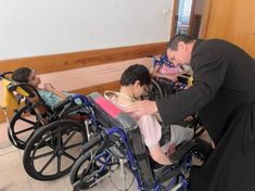 Fr Carlos Ferrero caring for some sick children Image: © ACN