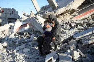 Mother and child on ruin of their home