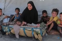 Displaced family in front of their tent in Gaza. © UNICEF/Mohammed Nateel
