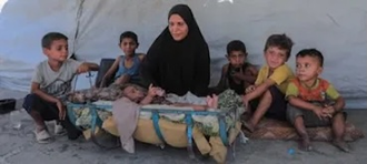 Displaced family in front of their tent in Gaza. © UNICEF/Mohammed Nateel