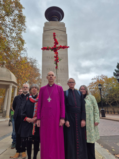 Clergy with red cross of poppies in front of Commonwealth Memorial Gates. Image: CFAWB