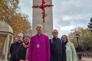 Clergy with red cross of poppies in front of Commonwealth Memorial Gates. Image: CFAWB
