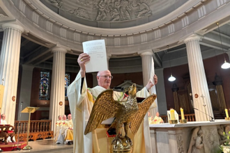During Mass Archbishop Farrell holds up the Papal decree at St Mary's Cathedral. Image: CCO