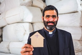 Father Lucas shows cardboard picture of the unfinished parish centre. Image:  ACN