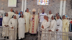 Tobias Yahaya hold his award next to Bishop Matthew Kukah during the special Mass